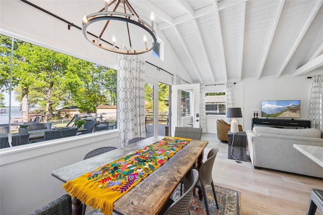 dining space with vaulted ceiling with beams, an inviting chandelier, and wood finished floors