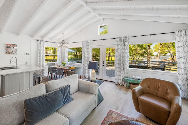 sunroom featuring a sink, french doors, and vaulted ceiling with beams