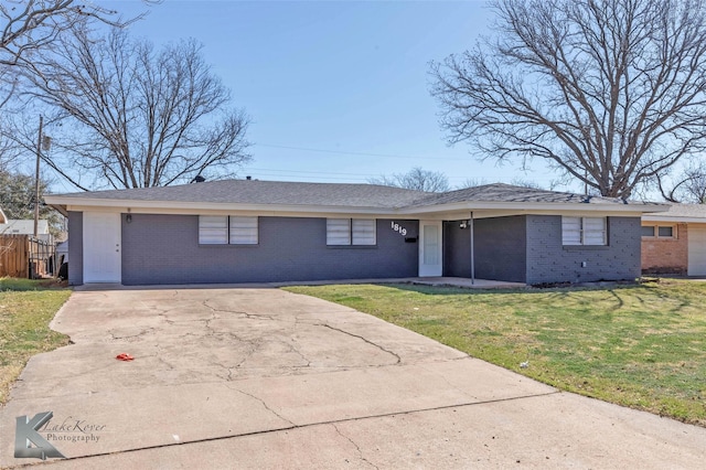 ranch-style house with brick siding, concrete driveway, a front lawn, and fence