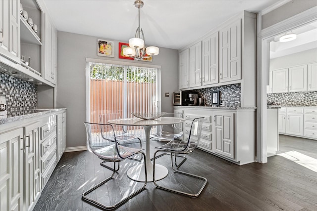 dining area with baseboards, dark wood-style flooring, and a chandelier