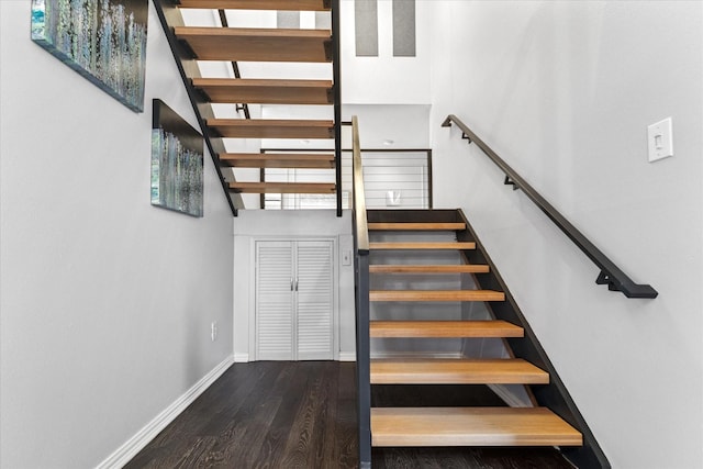 staircase with baseboards and wood finished floors