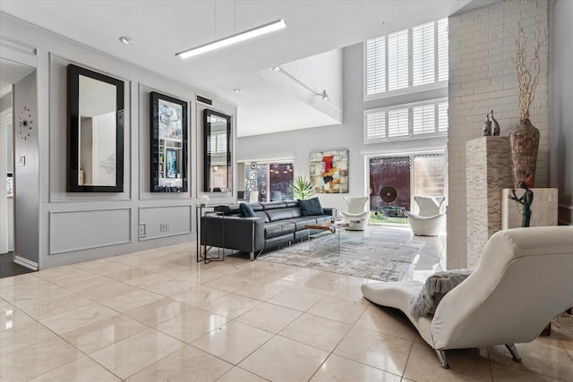 tiled living room featuring a decorative wall and a towering ceiling