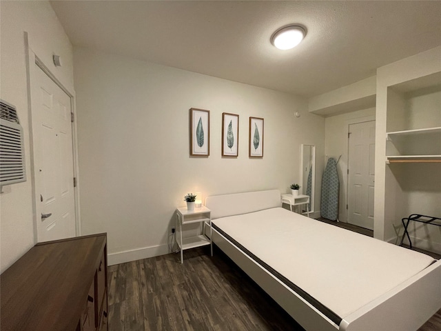 bedroom with dark wood-style floors and baseboards