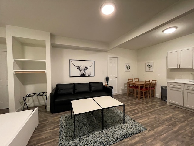 living area with dark wood-type flooring and baseboards