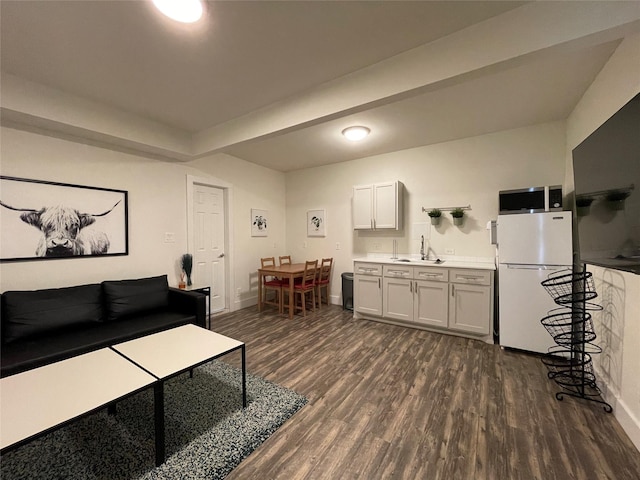 living area with baseboards and dark wood-type flooring