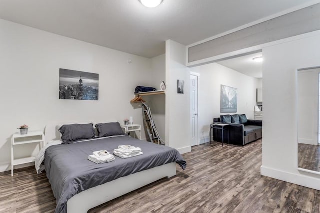 bedroom featuring baseboards and wood finished floors