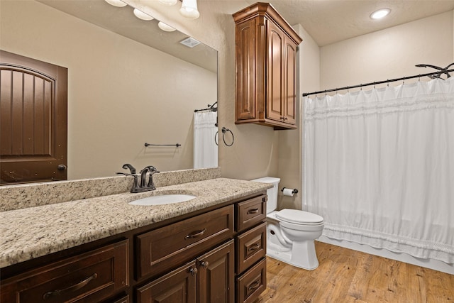 bathroom featuring visible vents, toilet, wood finished floors, recessed lighting, and vanity