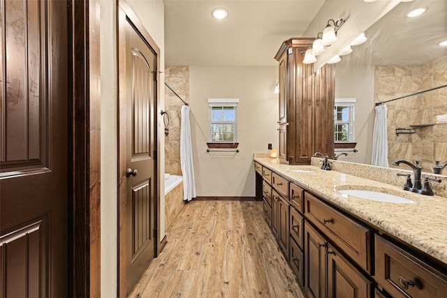 bathroom featuring a sink, baseboards, wood finished floors, and shower / bath combination with curtain