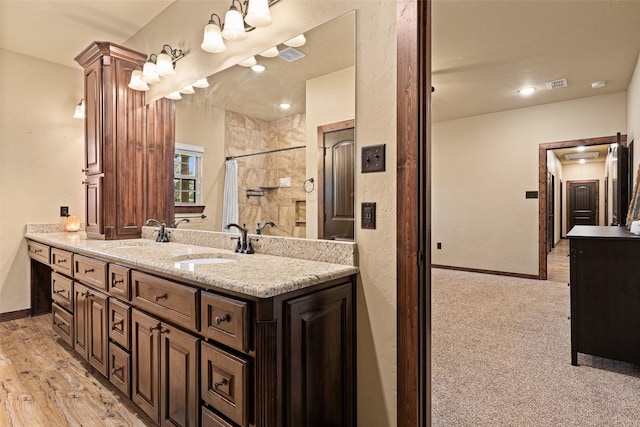 full bathroom featuring visible vents, wood finished floors, a shower with shower curtain, baseboards, and vanity