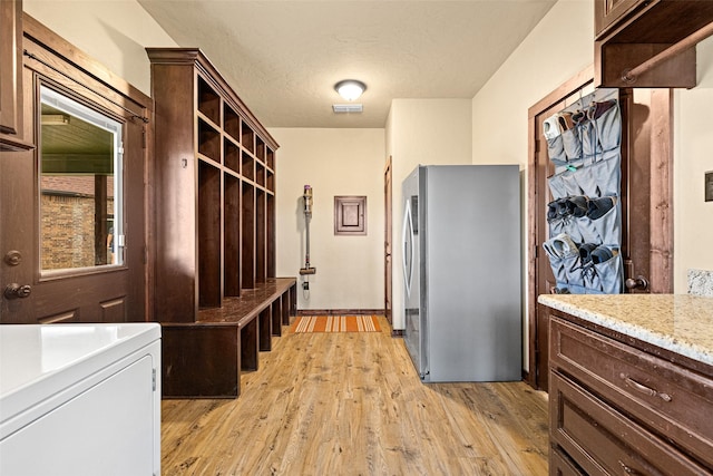 mudroom with light wood-style floors, visible vents, and a textured ceiling