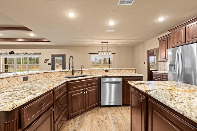 kitchen with stainless steel fridge, a healthy amount of sunlight, and a sink