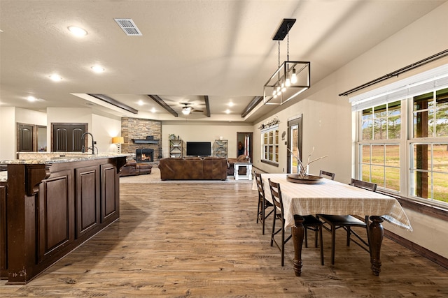 dining space with wood finished floors, visible vents, baseboards, recessed lighting, and a fireplace