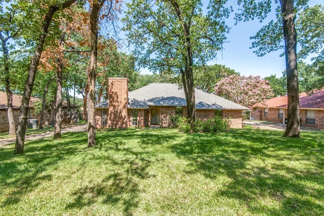 exterior space with brick siding and a yard