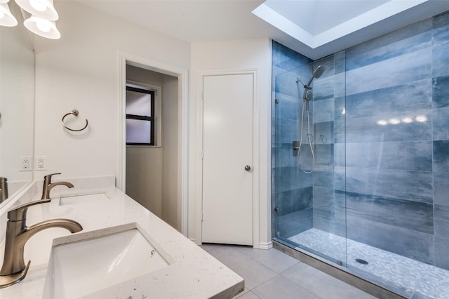 full bathroom featuring a sink, tiled shower, double vanity, and tile patterned floors