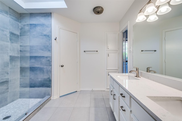 full bath with tiled shower, double vanity, a skylight, a sink, and tile patterned floors