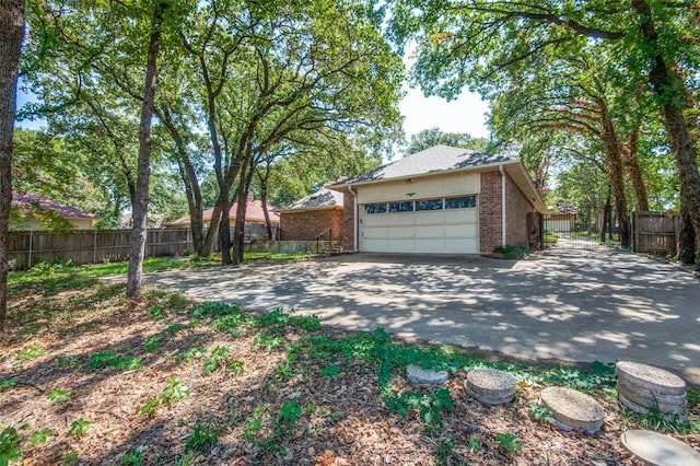 garage featuring driveway and fence