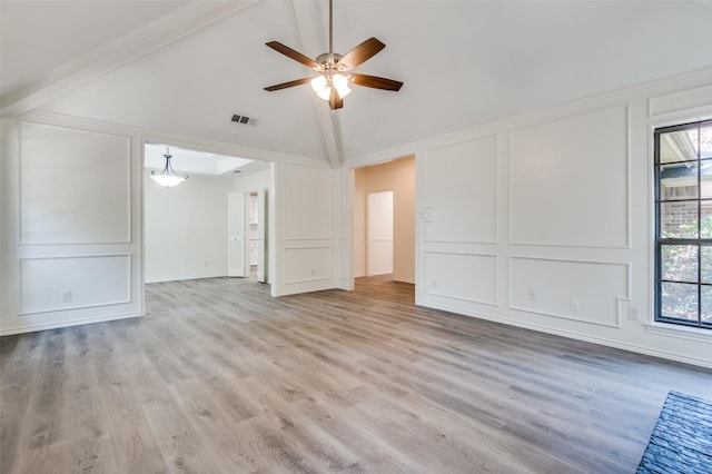 unfurnished living room featuring a decorative wall, a healthy amount of sunlight, visible vents, and light wood finished floors