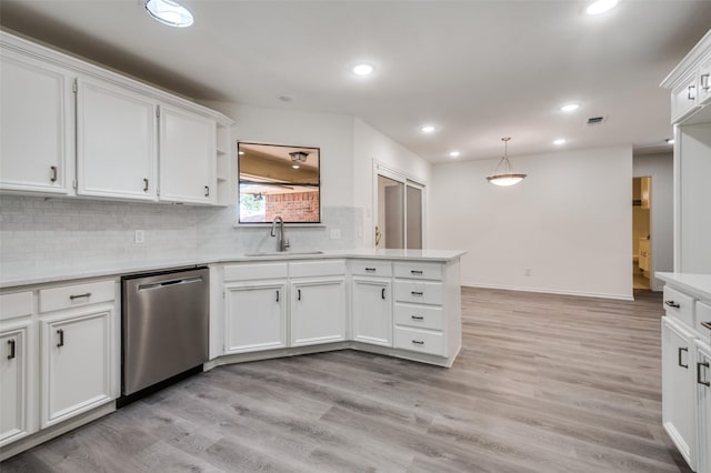 kitchen with white cabinetry, light wood finished floors, a peninsula, a sink, and dishwasher