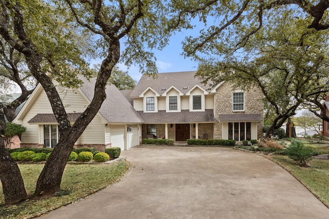 view of front of property with brick siding, a garage, driveway, and a shingled roof