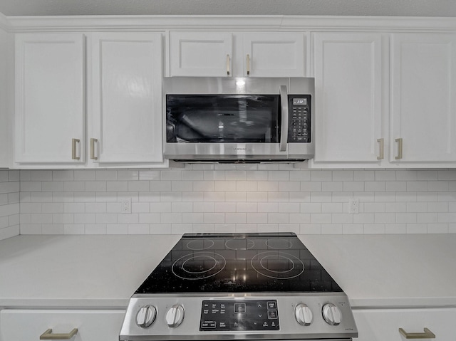 kitchen featuring white cabinetry, light countertops, appliances with stainless steel finishes, and decorative backsplash