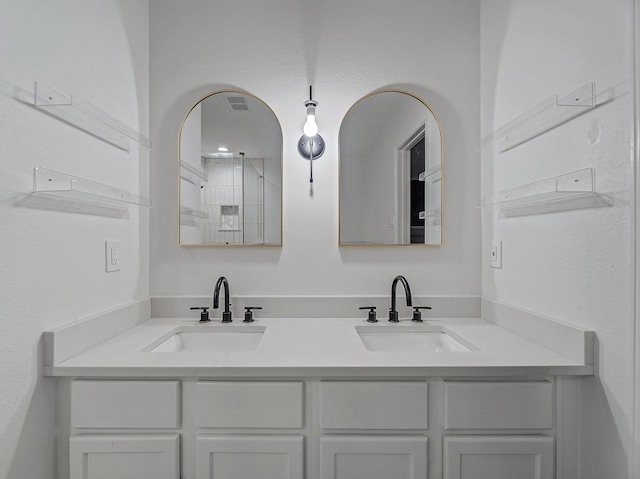 bathroom with double vanity, visible vents, and a sink