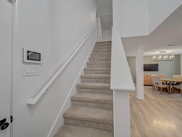 stairway featuring visible vents and wood finished floors