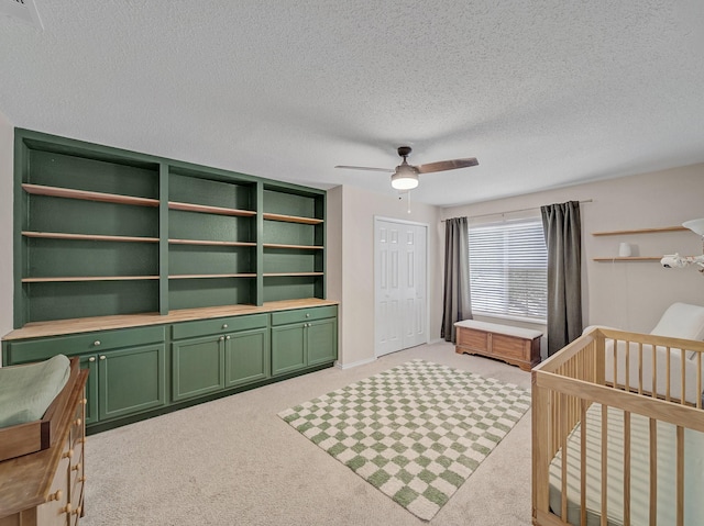 bedroom with a closet, light carpet, a textured ceiling, and ceiling fan