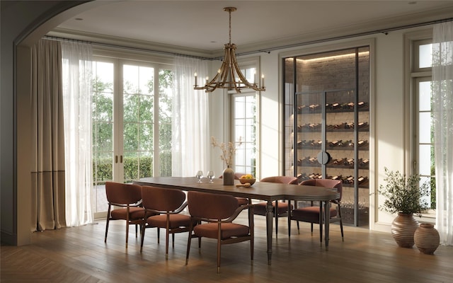 dining space featuring a notable chandelier, a healthy amount of sunlight, and wood finished floors