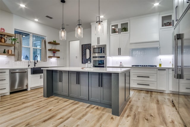 kitchen featuring open shelves, a sink, light countertops, white cabinets, and appliances with stainless steel finishes