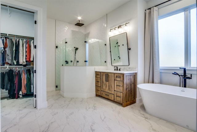 bathroom with a walk in closet, marble finish floor, a stall shower, and vanity