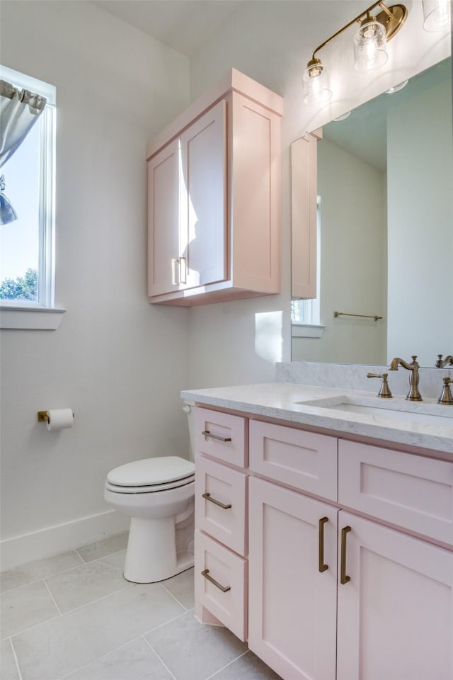 bathroom featuring vanity, toilet, baseboards, and tile patterned flooring