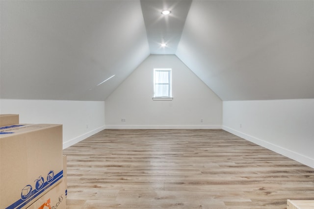 bonus room featuring vaulted ceiling, baseboards, and light wood finished floors