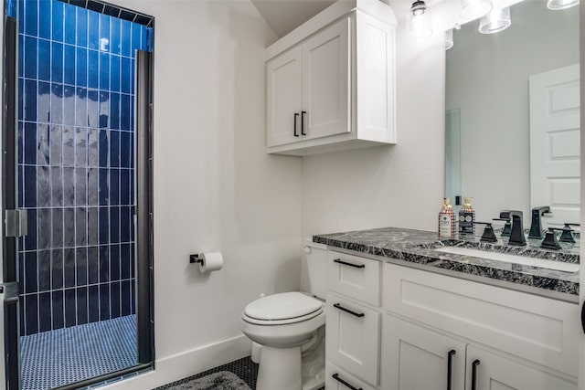 bathroom with vanity, toilet, baseboards, and tiled shower