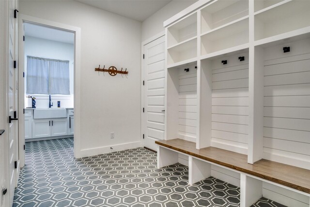 mudroom featuring baseboards and a sink