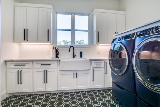 washroom featuring cabinet space, independent washer and dryer, and a sink