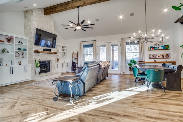 living area with beam ceiling, high vaulted ceiling, a notable chandelier, parquet floors, and a stone fireplace