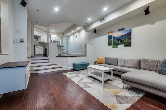 living room with visible vents, recessed lighting, stairs, and dark wood-style flooring