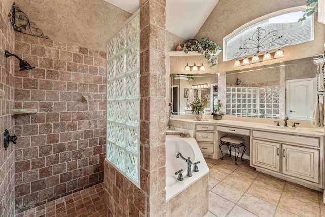 bathroom featuring vanity, a garden tub, a walk in shower, and vaulted ceiling