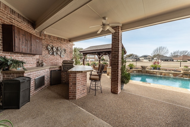 view of patio / terrace with a fenced backyard, outdoor wet bar, a grill, a fenced in pool, and an outdoor kitchen