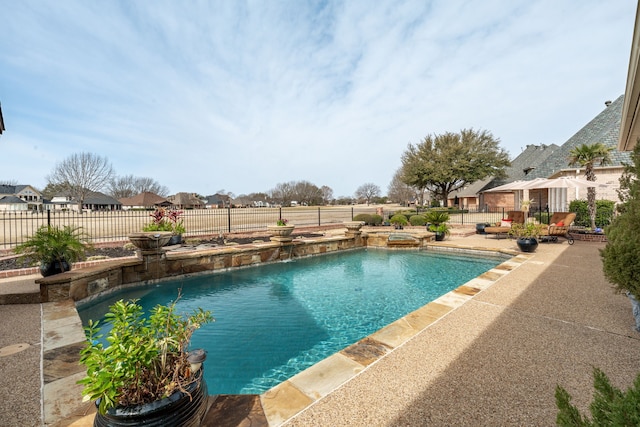 view of pool featuring a patio, a fenced backyard, and a pool with connected hot tub