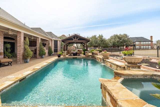 view of pool featuring a fenced backyard, a pool with connected hot tub, ceiling fan, a gazebo, and a patio area