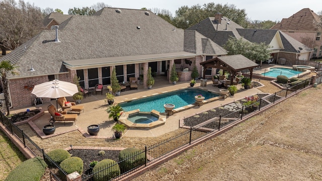 view of swimming pool with a pool with connected hot tub, an outdoor fire pit, a gazebo, a fenced backyard, and a patio area