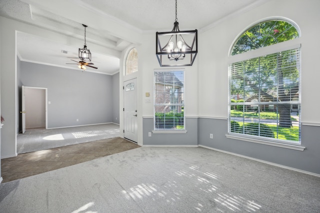 interior space with carpet floors, ceiling fan with notable chandelier, baseboards, and ornamental molding