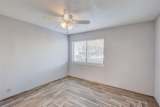 empty room featuring a textured ceiling, ceiling fan, and light wood finished floors