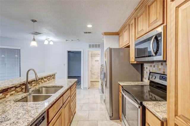 kitchen with light stone counters, visible vents, appliances with stainless steel finishes, and a sink