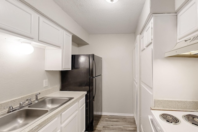 kitchen featuring white cabinetry, under cabinet range hood, light countertops, a textured ceiling, and a sink