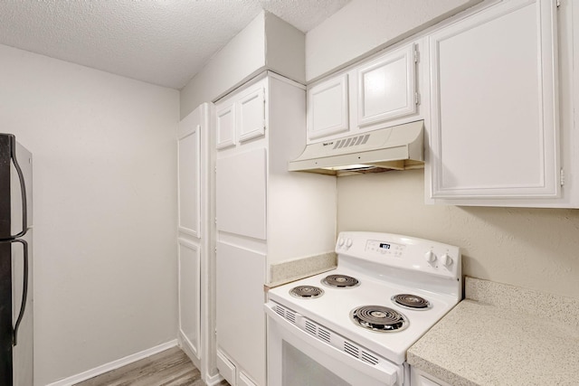 kitchen with under cabinet range hood, light countertops, freestanding refrigerator, white range with electric stovetop, and white cabinets