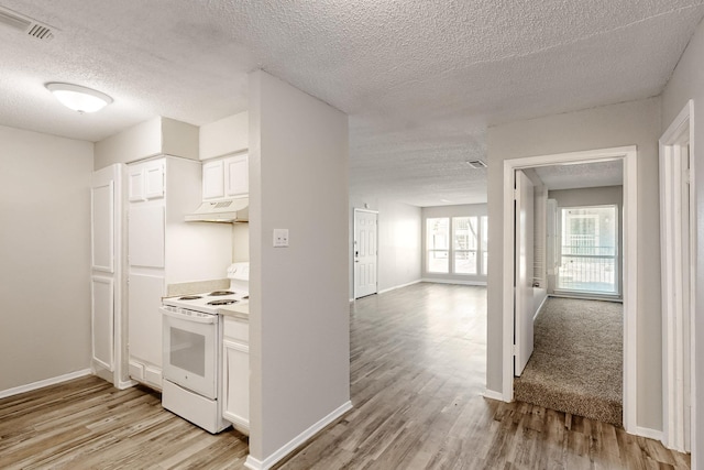 kitchen with visible vents, under cabinet range hood, light wood-type flooring, electric range, and white cabinetry