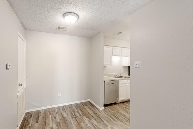 interior space featuring a sink, visible vents, baseboards, and light wood-style flooring