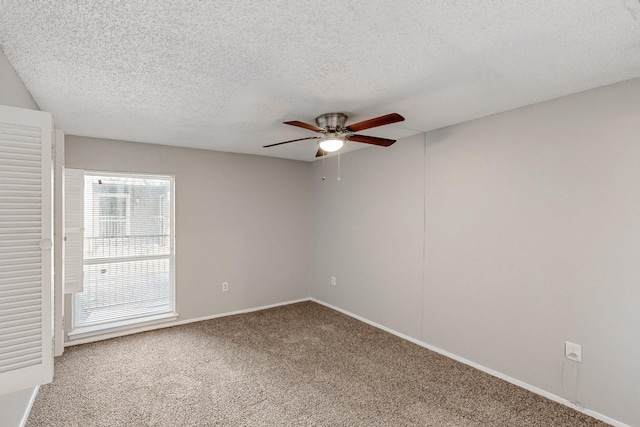 spare room with baseboards, a textured ceiling, a ceiling fan, and carpet